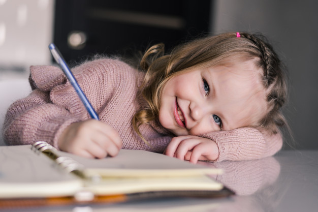 adorable-preschool-girl-drawing-with-pen-table_231208-65